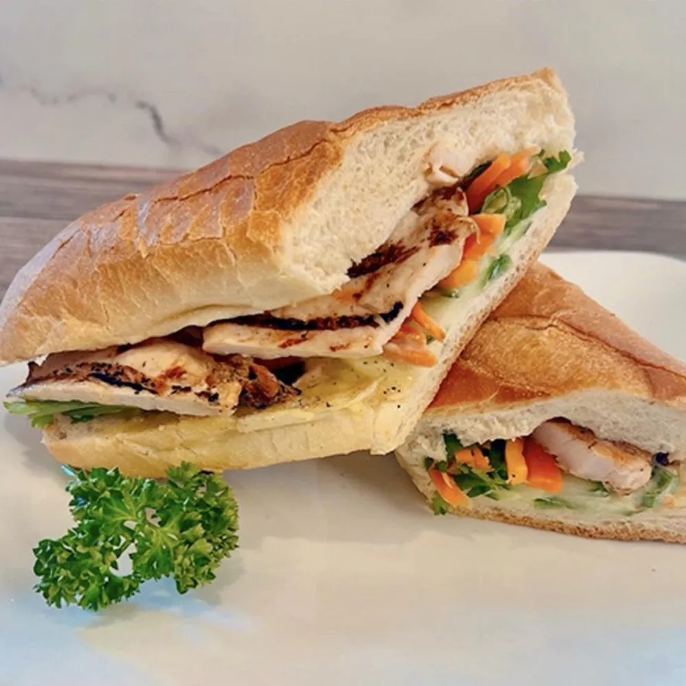 Grilled chicken sandwich fresh vegetable cheese soft baguette white plate garnish parsley at Su's Asian Street Kitchen, an Asian Fusion Restaurant in Westlake
